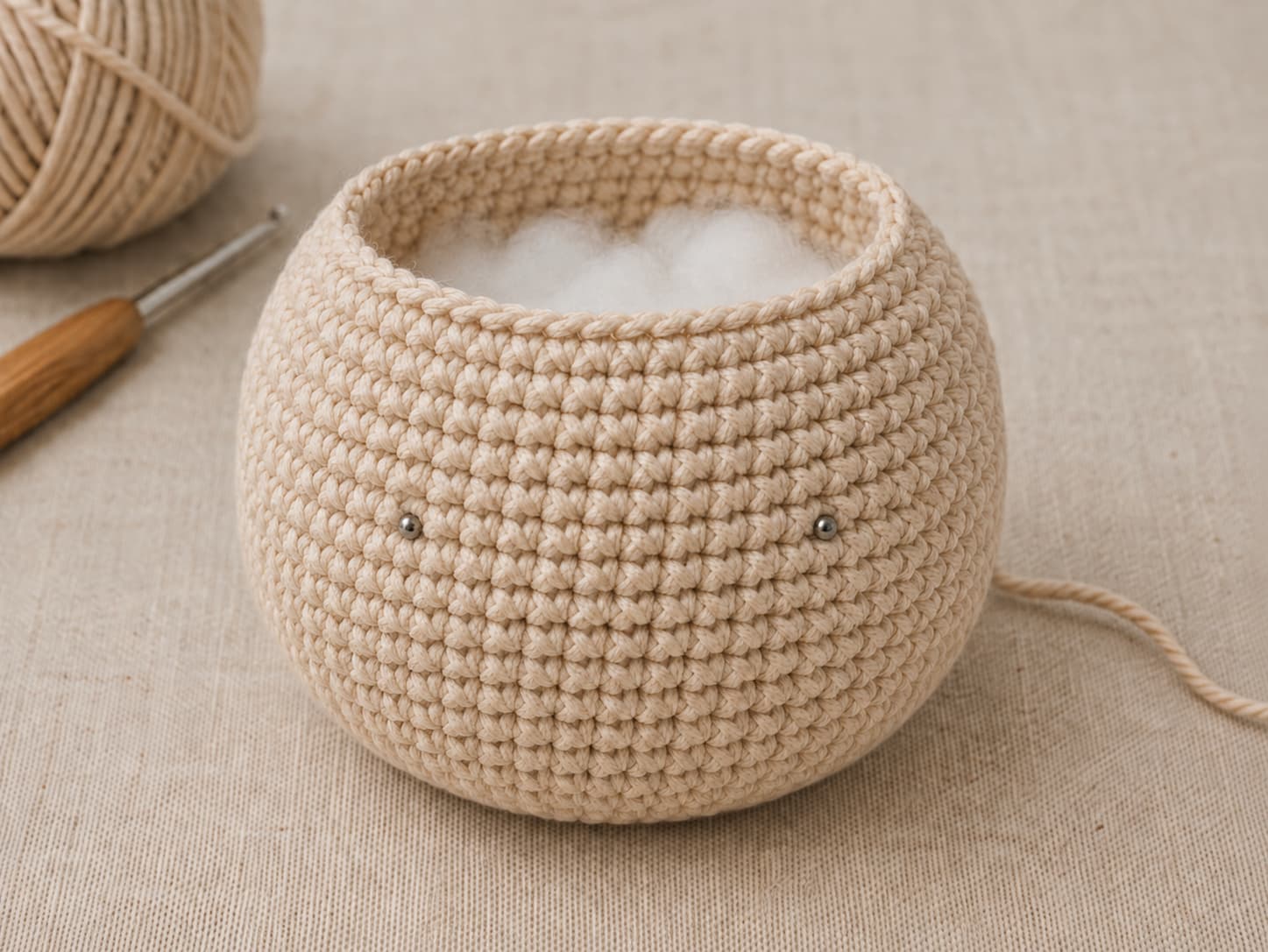 Open crochet amigurumi body showing eye placement before the final decrease rounds and before the opening is closed.