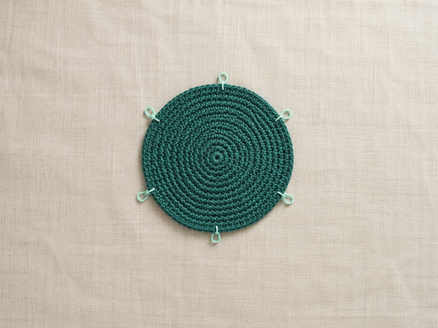 Deep jade-teal crochet market bag base worked as a flat single crochet circle with twelve increase rounds and seventy-two stitches beside evenly spaced markers.