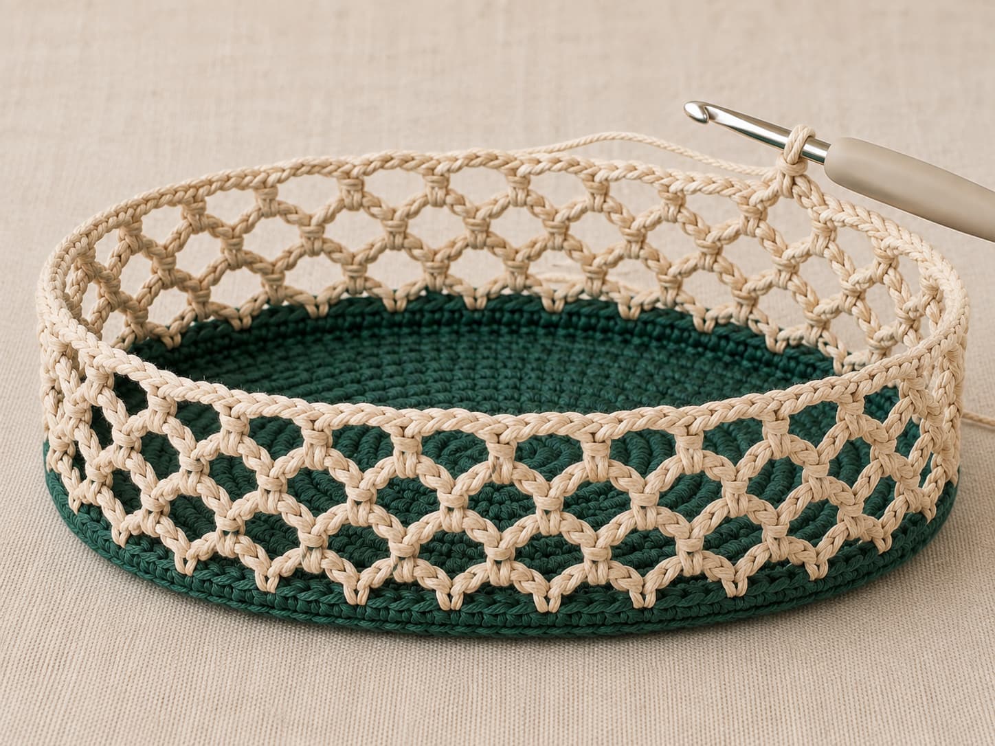 Warm-oatmeal chain-five crochet mesh rising from a deep jade-teal back-loop base edge with twenty-four evenly spaced anchor stitches.