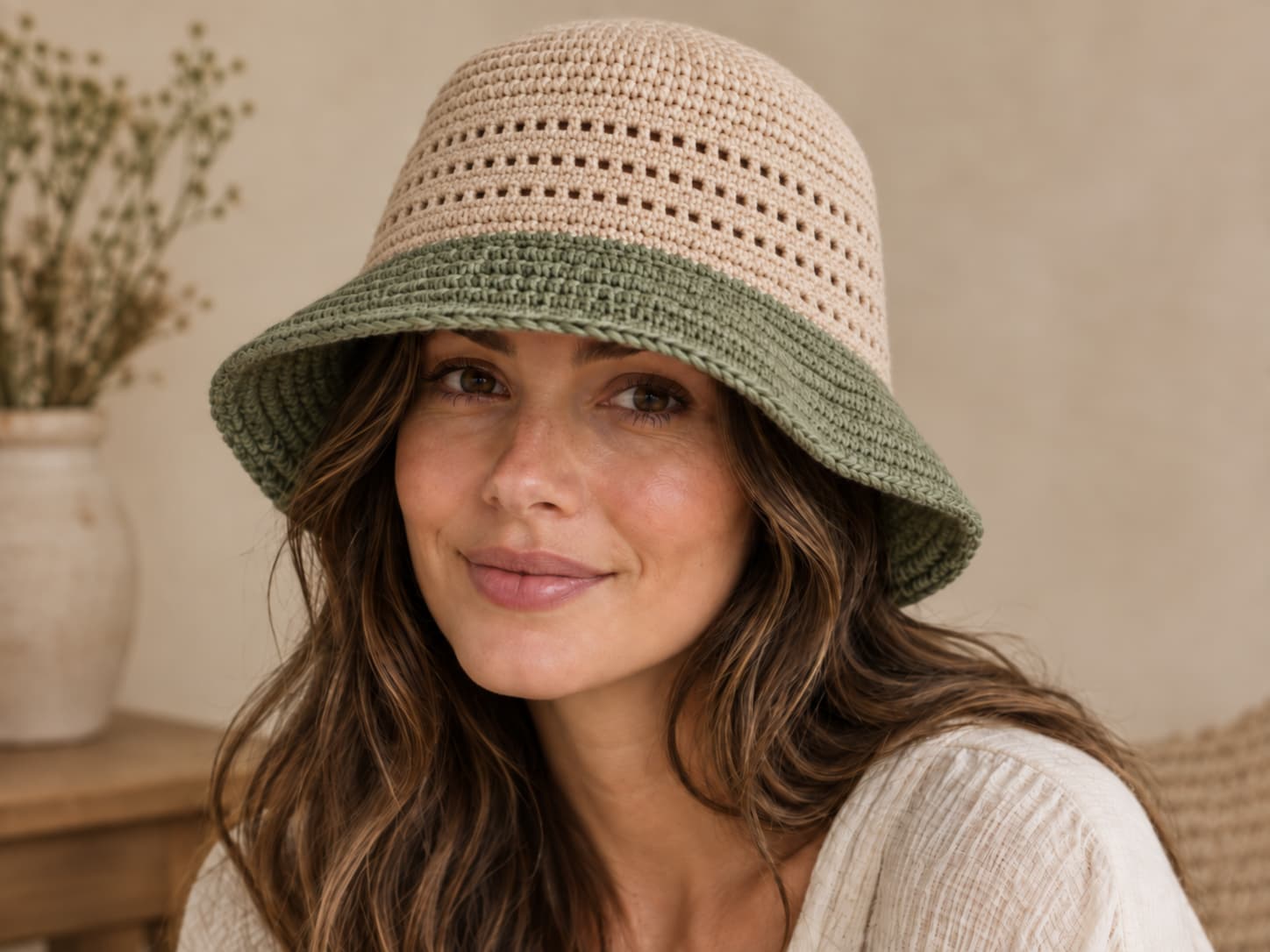 Finished crochet bucket hat in warm oatmeal with a soft sage brim worn on an adult model